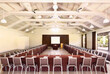 © Trinette Reed/Stocksy - Large business conference room event space with screen