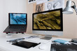 © Milles Studio/Stocksy - Computer monitor and laptop on artist desk