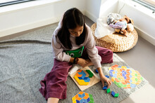 Girl Making Puzzle With Geometric Pieces