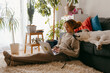 © Jimena Roquero/Stocksy - Woman working on laptop in home living room with dog