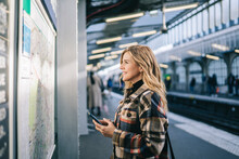 Happy Lady With Cellphone Checking Rout On Platform
