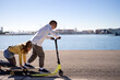 © Albert Martinez/Stocksy - Children riding skateboards with kick scooter near sea
