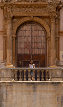 Woman Standing In Front Of A Huge Gate