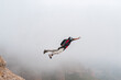 Thrill-seeker BASE jumping taking off from summit