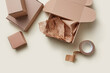 © Yaroslav Danylchenko/Stocksy - Boxes, craft paper and scotch on beige background