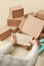 Female Hands Packing Cardboard Boxes