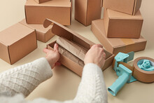 Woman Using Box, Paper And Scotch For Packing Parcels