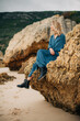 © Olga Moreira/Stocksy - Woman on the rock on the beach
