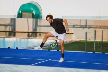 Wall Mural - Padel match in a blue grass padel court - Padel player playing a match