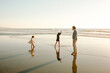 © Erin Brant/Stocksy - Dad watches daughters on beach at sunset