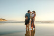 © Erin Brant/Stocksy - Laughing family at beach at sunset
