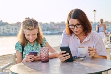 Poster - Mother and daughter child together in an outdoor cafe on the waterfront.