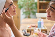 © Guille Faingold/Stocksy - Female doing makeup for girlfriend