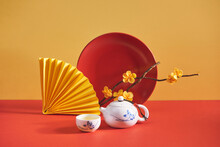 Yellow Apricot Flower In Vase With Tea Pot Isolated On Yellow And Red Background, Traditional Lunar New Year In Vietnam