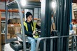 © Sergio Marcos/Stocksy - Storehouse worker riding electric forklift