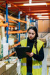 © Sergio Marcos/Stocksy - Young woman writing on clipboard in warehouse