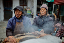 Older Chinese Sweet Potato Vendors At A Local Market