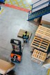 © Sergio Marcos/Stocksy - Worker sitting on wooden pallet near forklift