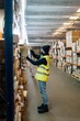© Sergio Marcos/Stocksy - Woman taking box from box in warehouse