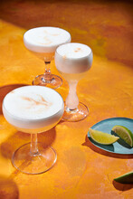 Cocktails In Coupe Glasses With Foam And Limes