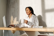 African American Lady Drinking Coffee And Using Laptop