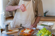 © Alba Vitta/Stocksy - Senior man cooking preparing healhty meal in kitchen