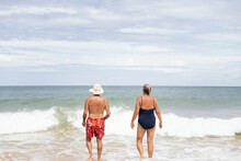 Elderly Couple Entering The Sea To Swim