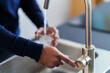 © Studio Marmellata/Stocksy - Man pouring water from tap in sink