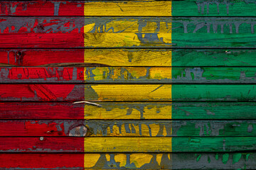 Wall Mural - The national flag of Guinea is painted on uneven boards. Country symbol.