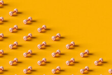 Pink Dumbbells On An Orange Background With Copy Space.