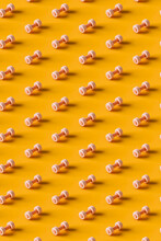 Pattern Of Pink Dumbbells On An Orange Background. 