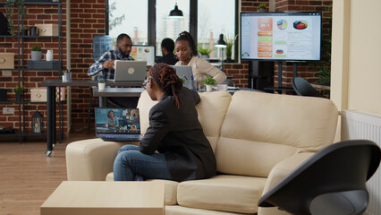 Poster - Young employee attending business meeting on videocall, using laptop with internet connection. Woman talking to colleagues on online videoconference, remote communication on teleconference call.