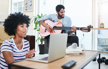 Poster - I wrote this for the love of my life. Shot of a woman using her laptop while her boyfriend plays the guitar.