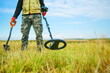 man holds a metal detector in nature in search of treasure. close-up demining