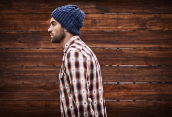 Poster - Styled for the street. Shot of a handsome young man in trendy winter attire against a wooden background.