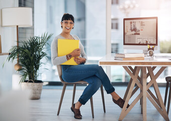 Wall Mural - I love my job. Full length portrait of an attractive young businesswoman sitting alone and holding files in her office.