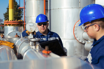 Two Factory worker in a hard hat on Heavy equipment and pipeline