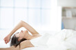 © amanaimages - ベッドで伸びをする寝起きの女性