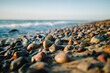 runde steine am Strand im Hintergrund das Meer horizontal