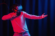 © endrews21 - bearded man in gray golf and virtual reality glasses in neon light on a dark background is studying martial arts in the metaverse