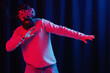 © endrews21 - adult bearded man in gray golf and virtual reality glasses dancing disco in neon light on black background