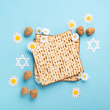 Passover Greeting Card With Matzah, Nuts And Daisy Flowers On Blue Background.