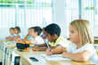 © JackF - School children writing test, smart young people studying at primary school