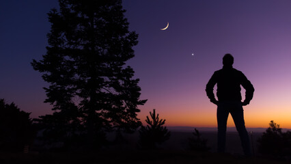 Wall Mural - man observing evening sky with stars, planets and crescent moon.