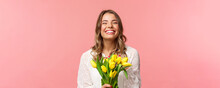 Spring, Happiness And Celebration Concept. Close-up Of Happy And Carefree Blond European Girl Receive Beautiful Bouquet Of Flowers, Holding Yellow Tulips, Smiling And Laughing, Pink Background