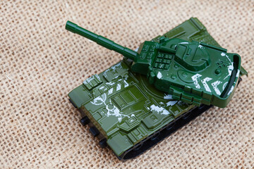 Tanks and war time army toys on rustic hessian surface