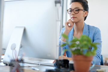 Poster - Working towards financial stability. Professional young woman thinking while looking at the screen of her pc in her office.
