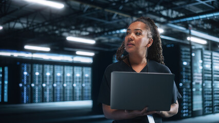 Poster - Portrait of a Young Creative Caucasian Female with Blonde Hair Using a Tablet Computer in Evening Office. Beautiful Independent Woman is Walking Through the Office and Looking Away