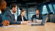 Smiling business analysts discussing a project at a meeting