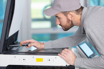 young apprentice fixing cartridge in photocopy machine